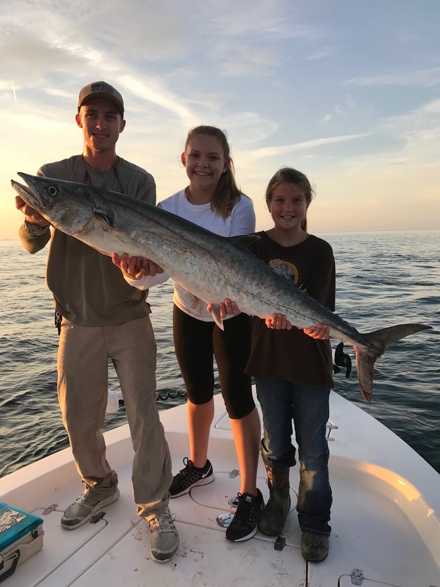 family holding fish on the boat